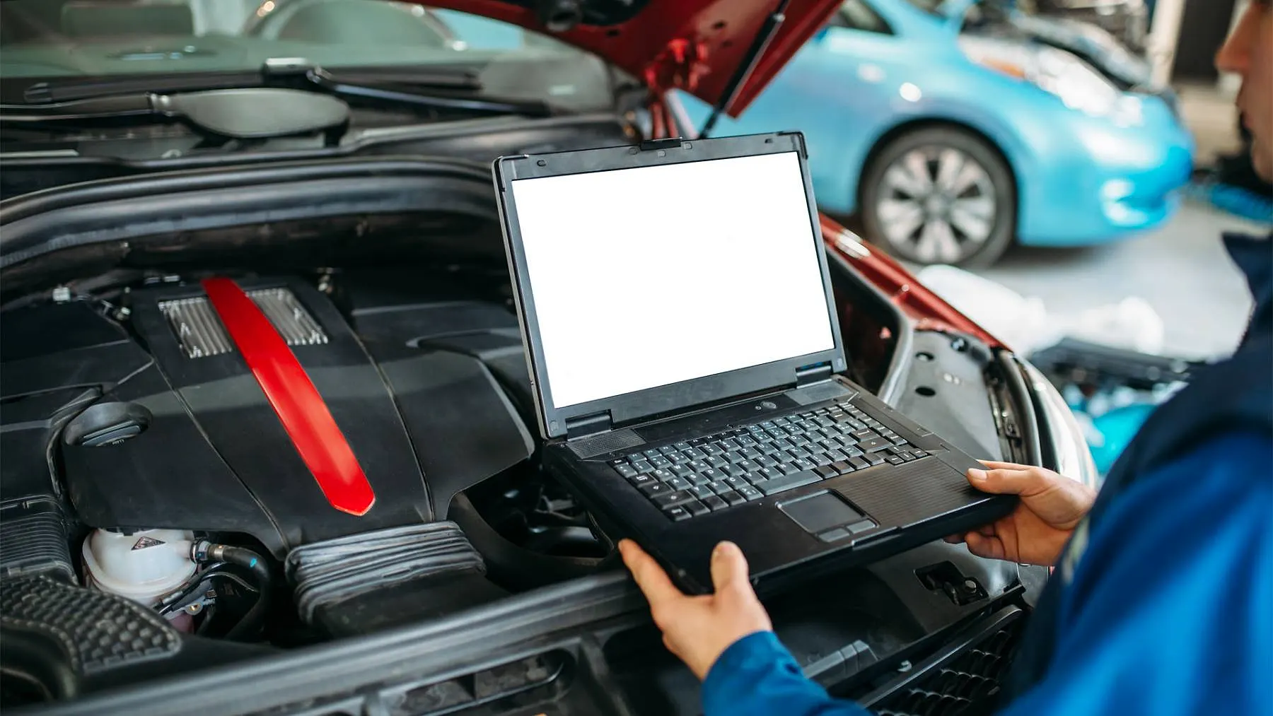 Engineer running computer diagnostics on a car engine at Raimondi Auto Services Old Woking